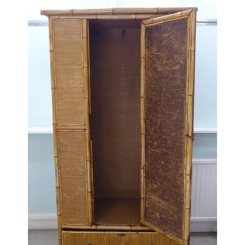 231 - A post World War II Oriental style bamboo and rattan finished wardrobe with a central mirrored door,... 