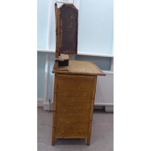 235 - A post World War II Oriental style bamboo and rattan finished dressing table, surmounted by a tripty... 