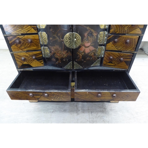 237 - A 20thC Japanese black painted and fruitwood marquetry inlaid table top cabinet with an arrangement ... 