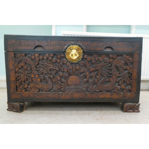 239 - A 20thC Chinese camphorwood blanket chest, profusely carved with dragons and clouds, having straight... 