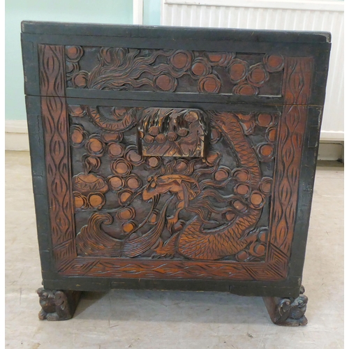 239 - A 20thC Chinese camphorwood blanket chest, profusely carved with dragons and clouds, having straight... 