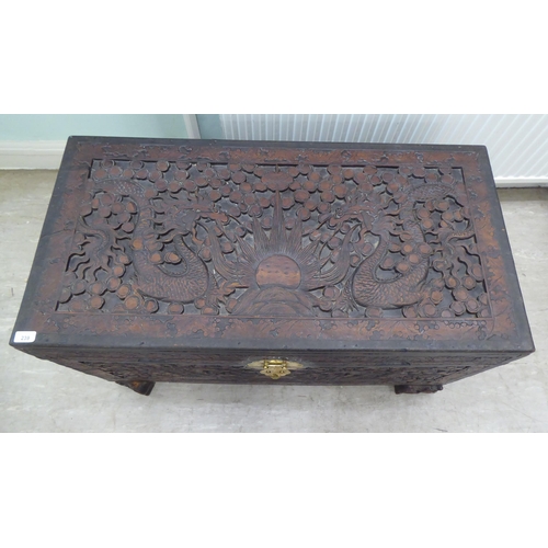 239 - A 20thC Chinese camphorwood blanket chest, profusely carved with dragons and clouds, having straight... 