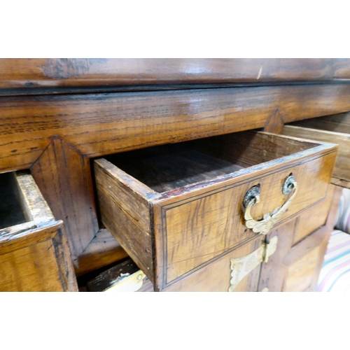 241 - A 20thC Korean brass bound fruitwood chest with an arrangement of cupboard doors and drawers, in two... 