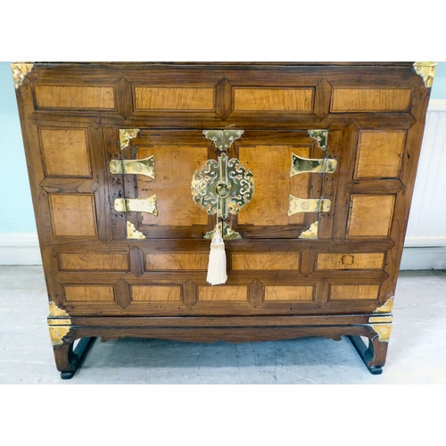 241 - A 20thC Korean brass bound fruitwood chest with an arrangement of cupboard doors and drawers, in two... 