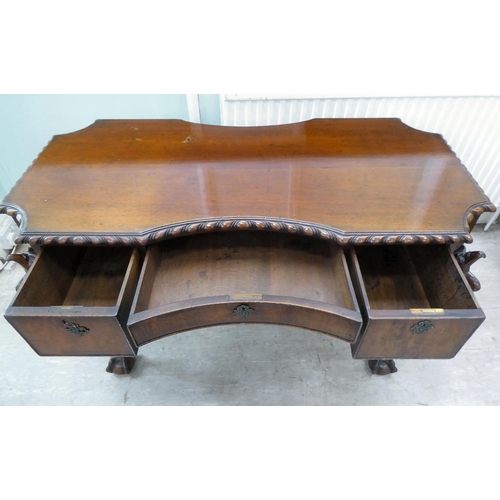 299 - An Edwardian mahogany concave front desk, the top with a gadroon moulded edge, over three drawers, r... 