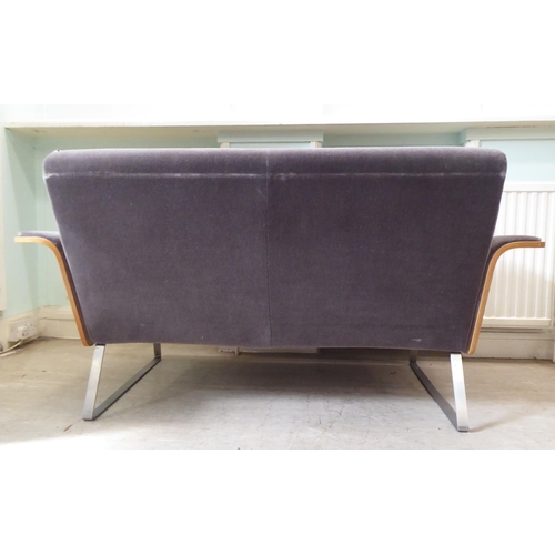 323 - A Robin Day AV2 laminate two person settee, upholstered in a charcoal coloured fabric, raised on chr... 