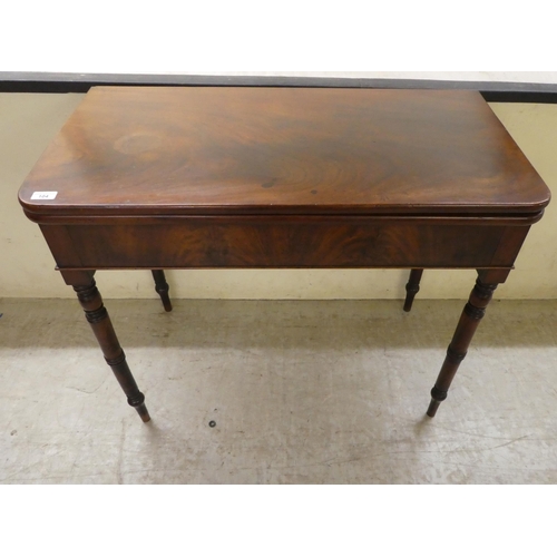 104 - A 19thC mahogany tea table, the foldover top raised on ring turned legs  29