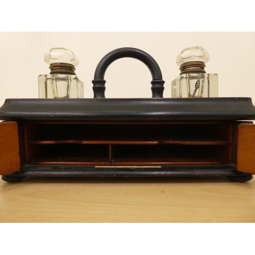 122 - A mid Victorian walnut finished inkwell deskstand with two pen reservoirs, over a hinged door  ... 