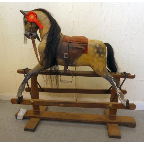 147 - An early 20thC carved and overpainted nursery rocking horse, on a plinth plinth  39