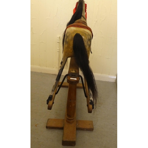 147 - An early 20thC carved and overpainted nursery rocking horse, on a plinth plinth  39