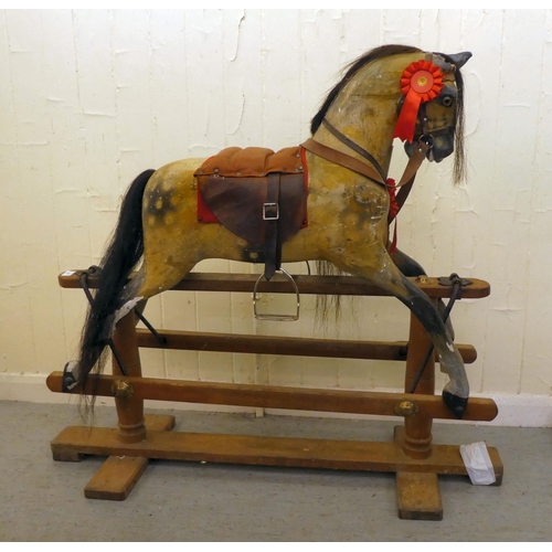 147 - An early 20thC carved and overpainted nursery rocking horse, on a plinth plinth  39