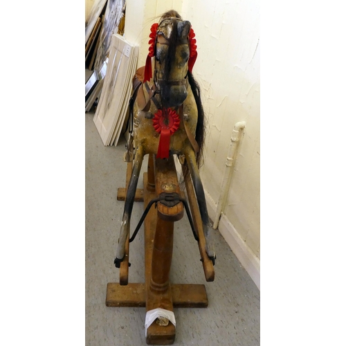 147 - An early 20thC carved and overpainted nursery rocking horse, on a plinth plinth  39