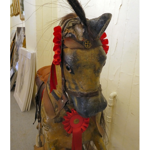 147 - An early 20thC carved and overpainted nursery rocking horse, on a plinth plinth  39