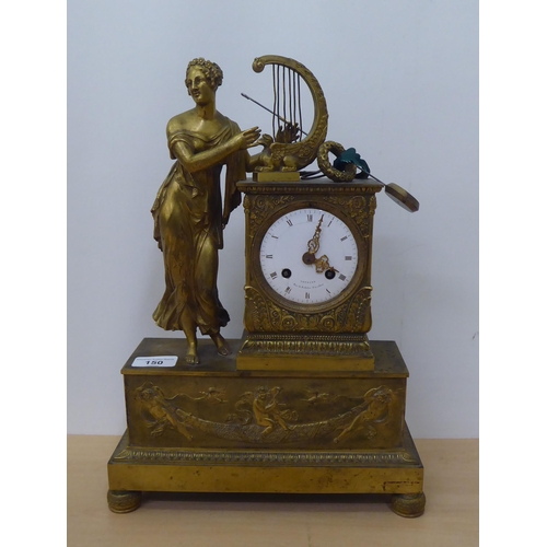 150 - An early 20thC French gilt metal cased mantel clock with a figure and harp; the Venault of Paris mov... 