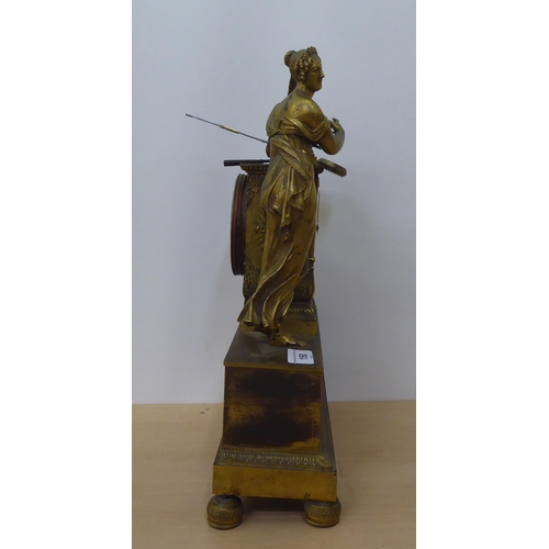 150 - An early 20thC French gilt metal cased mantel clock with a figure and harp; the Venault of Paris mov... 