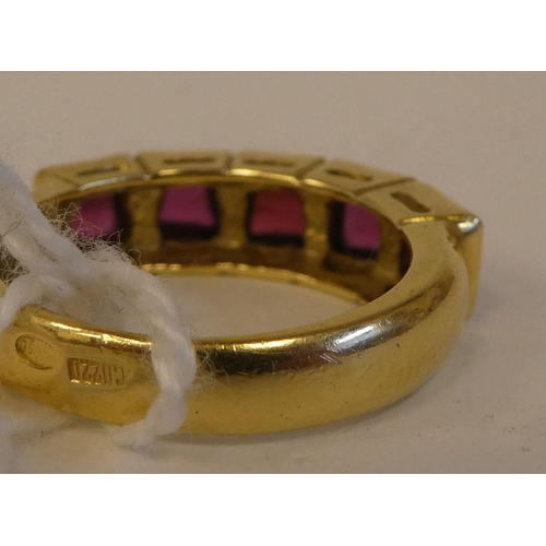 165 - A yellow metal (possibly 18ct) ring, set with five garnets  