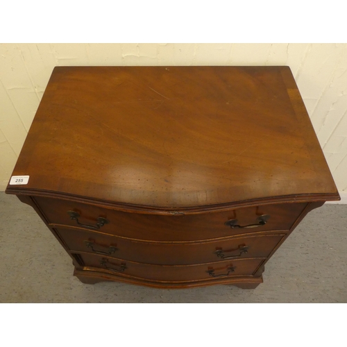 255 - An early/mid 20thC crossbanded mahogany serpentine front three drawer bedside chest, raised on brack... 