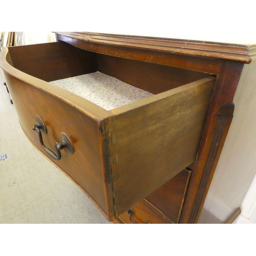 255 - An early/mid 20thC crossbanded mahogany serpentine front three drawer bedside chest, raised on brack... 