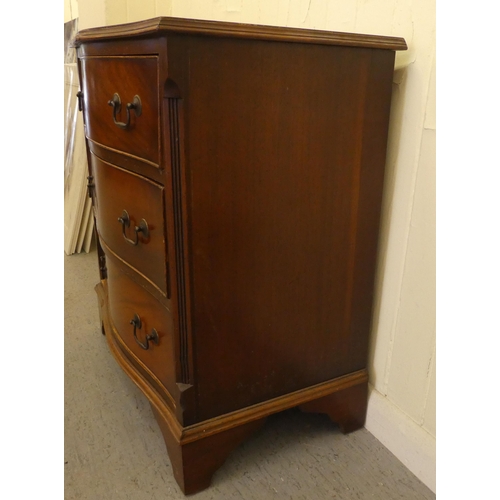 255 - An early/mid 20thC crossbanded mahogany serpentine front three drawer bedside chest, raised on brack... 