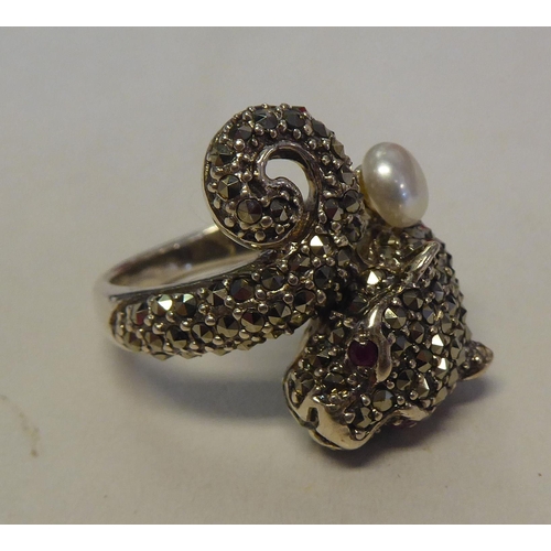 285 - A silver coloured metal and marcasite Panther style ring with ruby set eyes