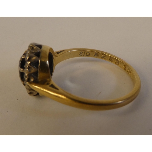 290 - An 18ct gold ring, set with a dark blue stone, surrounded by white stones