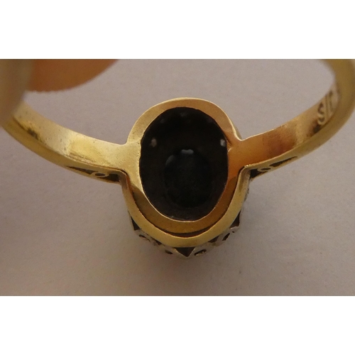 290 - An 18ct gold ring, set with a dark blue stone, surrounded by white stones