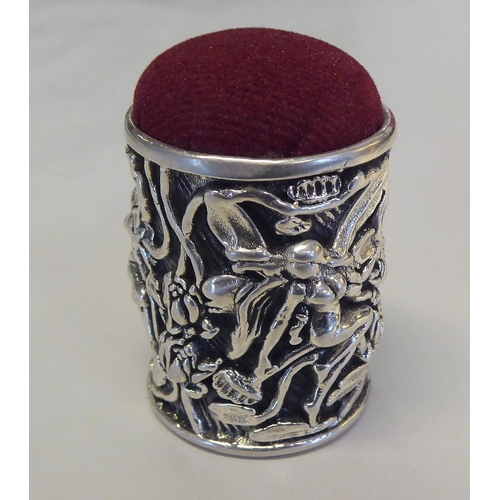 309 - A silver coloured metal barrel design, novelty pin cushion, cast with fairyland figures