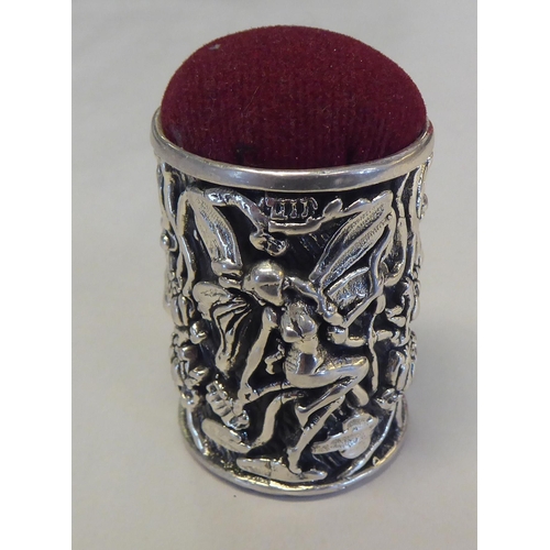 309 - A silver coloured metal barrel design, novelty pin cushion, cast with fairyland figures