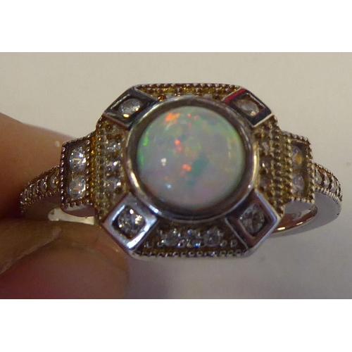 314 - A silver coloured metal, cubic zirconia and opal set ring