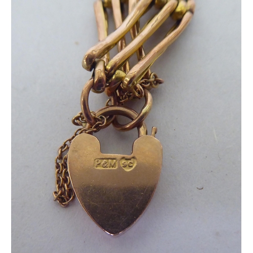 367 - A 9ct gold gate link bracelet, on a heart shaped padlock clasp, on a safety chain 