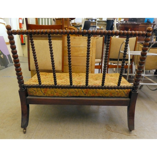 397 - A late Victorian faux rosewood framed bobbin turned salon settee, raised on casters 