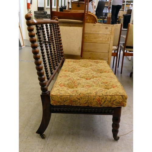 397 - A late Victorian faux rosewood framed bobbin turned salon settee, raised on casters 