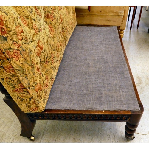 397 - A late Victorian faux rosewood framed bobbin turned salon settee, raised on casters 