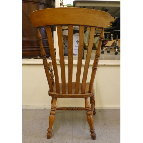 399 - A late Victorian elm and beech framed grandfather chair with a slatted back and solid seat, raised o... 