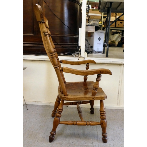 399 - A late Victorian elm and beech framed grandfather chair with a slatted back and solid seat, raised o... 