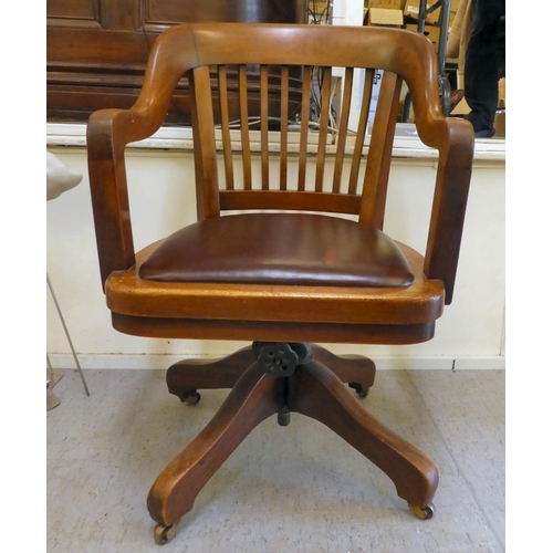 400 - An Edwardian mahogany framed revolving desk chair, raised on casters 