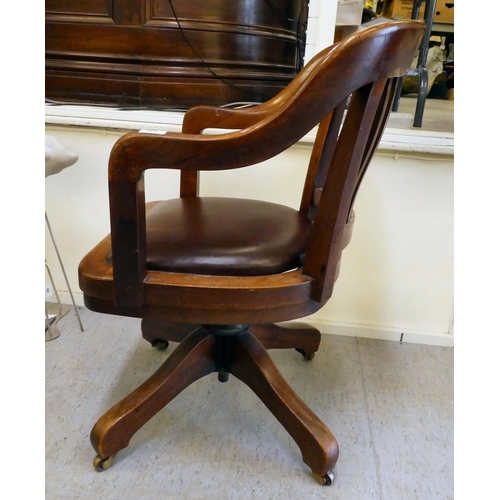 400 - An Edwardian mahogany framed revolving desk chair, raised on casters 