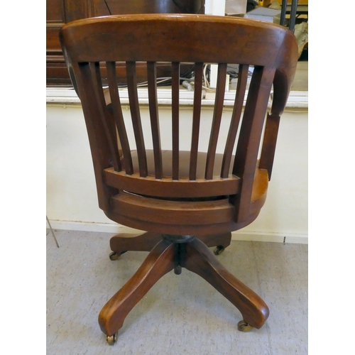 400 - An Edwardian mahogany framed revolving desk chair, raised on casters 