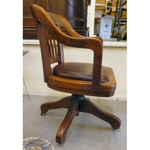 400 - An Edwardian mahogany framed revolving desk chair, raised on casters 