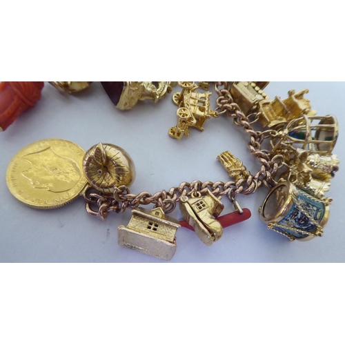 405 - A 9ct gold charm bracelet with various charms, featuring an apple containing Adam & Eve, a parro... 