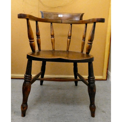 409 - An early 20thC elm and beech framed captain's chair with a solid seat, raised on turned legs