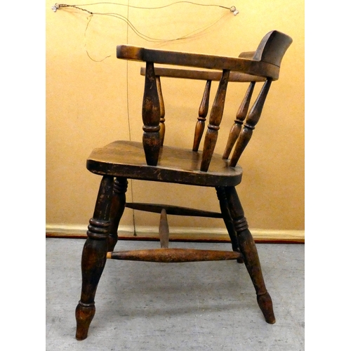 409 - An early 20thC elm and beech framed captain's chair with a solid seat, raised on turned legs