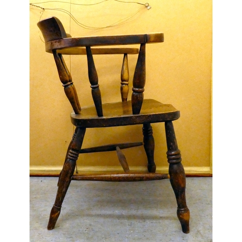 409 - An early 20thC elm and beech framed captain's chair with a solid seat, raised on turned legs