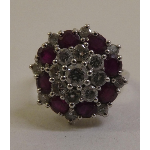 55 - An 18ct white gold, ruby and diamond set, floral design cluster ring