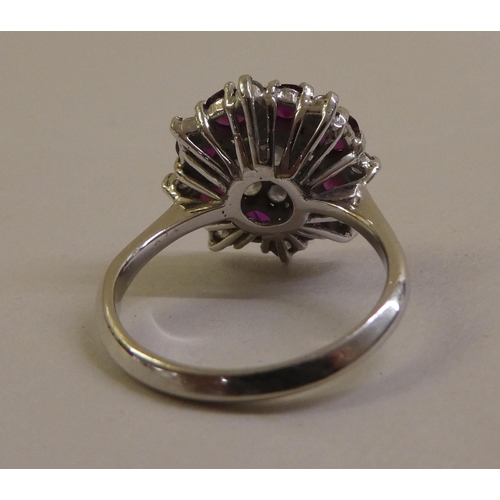 55 - An 18ct white gold, ruby and diamond set, floral design cluster ring