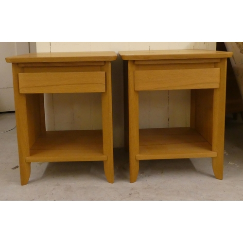 74 - A pair of modern light oak bedside chests with a single drawer, over an open shelf, raised on straig... 