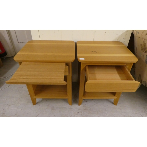 74 - A pair of modern light oak bedside chests with a single drawer, over an open shelf, raised on straig... 