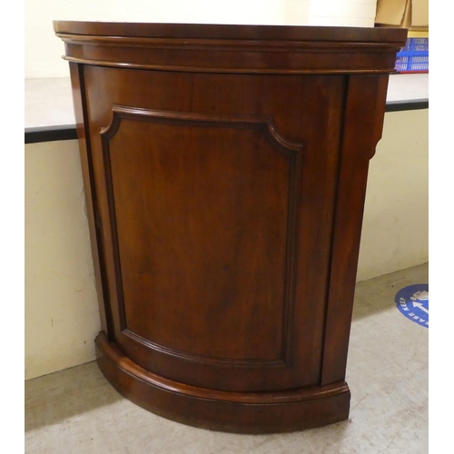 76 - A late Victorian mahogany corner cabinet with a panelled door, on a plinth  40