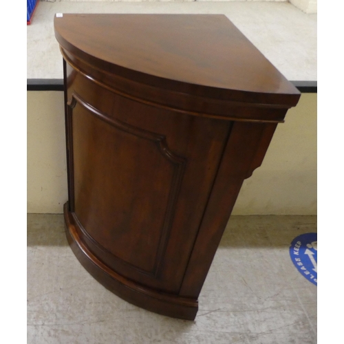 76 - A late Victorian mahogany corner cabinet with a panelled door, on a plinth  40