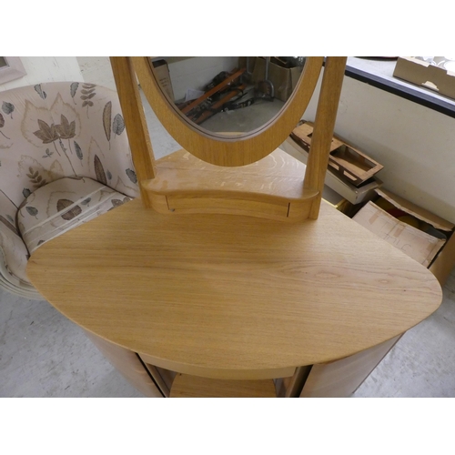 77 - A modern light oak dressing table, surmounted by an oval mirror and single drawer base, over two ped... 